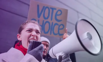 German police standing in front of protesters waving the Palestine flag